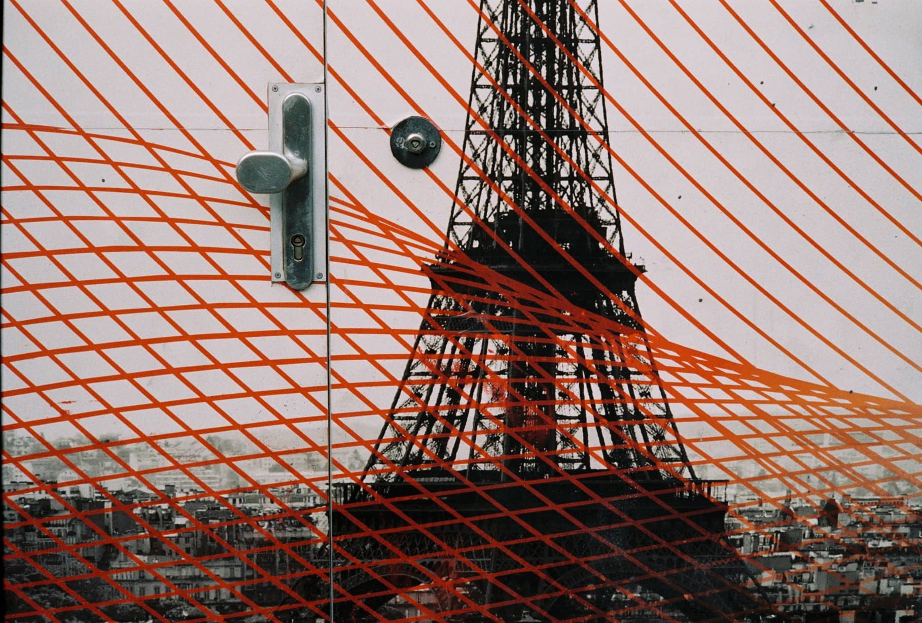 Tür mit Eiffelturm-Motiv, überlagert von einem orangefarbenen Streifenmuster